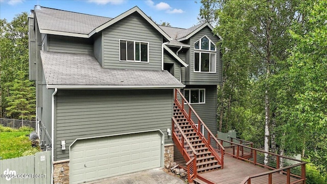 21009 River Park Dr, Eagle River, AK 99577 - back of property with an attached garage, stairs, a shingled roof, a wooden deck, and driveway