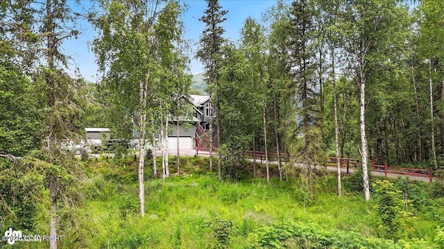 21009 River Park Dr, Eagle River, AK 99577 - view of yard with a garage and a view of trees