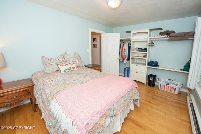 326 W 10th Ave, Anchorage, AK 99501 - bedroom with a baseboard heating unit, wood finished floors, and a closet