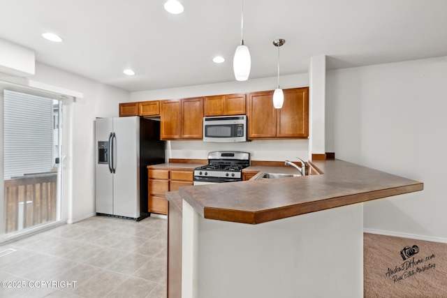 6507 Kara Sue Loop # 83, Anchorage, AK 99504 - kitchen with stainless steel appliances, brown cabinetry, a peninsula, pendant lighting, and recessed lighting