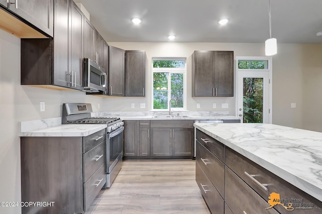 12229 Vista Ridge Loop, Eagle River, AK 99577 - kitchen featuring appliances with stainless steel finishes, light wood-type flooring, dark brown cabinetry, recessed lighting, and light stone counters