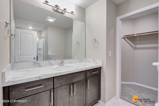 12229 Vista Ridge Loop, Eagle River, AK 99577 - bathroom with vanity, a spacious closet, and a shower with door