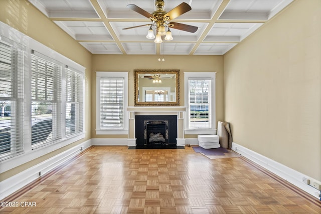 unfurnished living room featuring coffered ceiling, plenty of natural light, and light parquet flooring