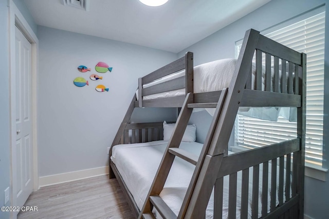 bedroom featuring baseboards, visible vents, and wood finished floors