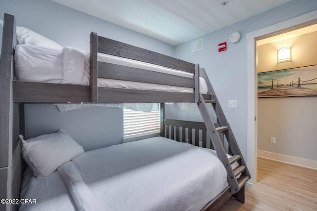 bedroom featuring visible vents, baseboards, and wood finished floors