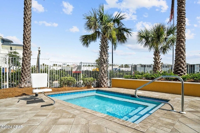 view of pool with a patio area and fence