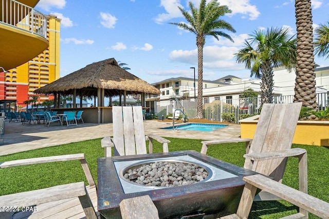 view of yard with fence, a fire pit, a pool, and a patio