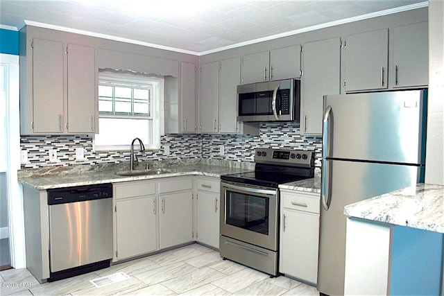 kitchen featuring sink, gray cabinets, crown molding, backsplash, and stainless steel appliances