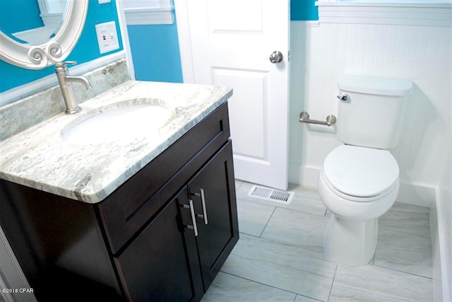 bathroom with tile floors, large vanity, and toilet