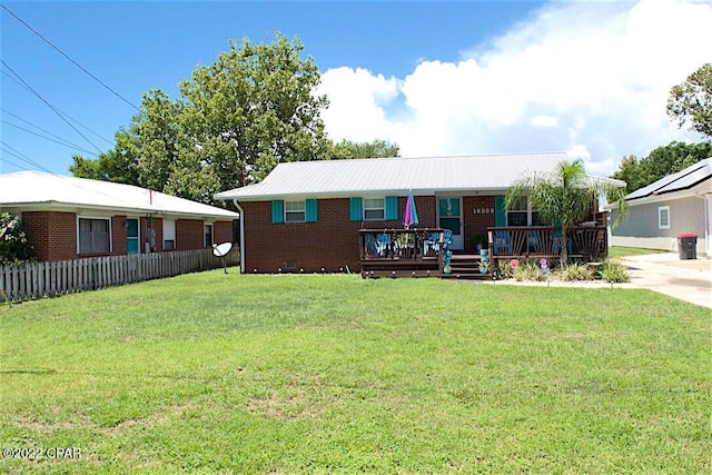 ranch-style house featuring a front yard and solar panels