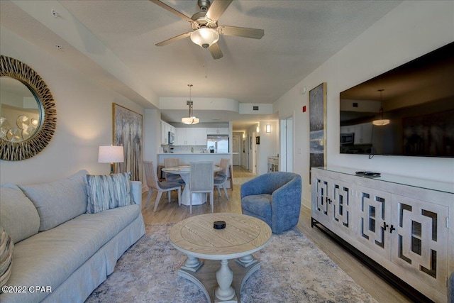 living room with ceiling fan and light wood-type flooring