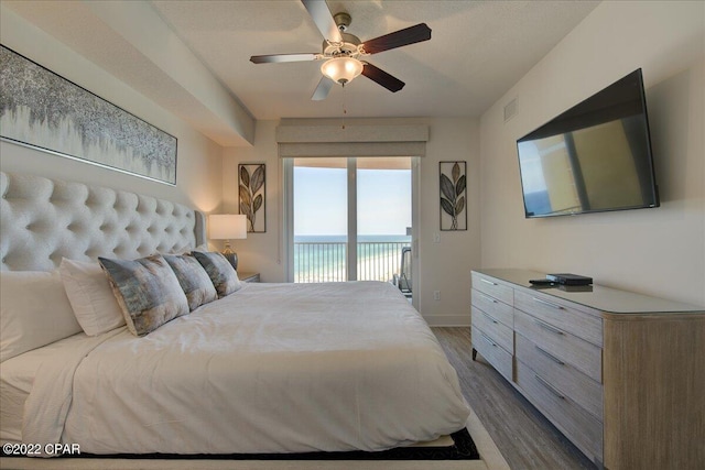 bedroom with dark wood-type flooring, ceiling fan, and access to outside