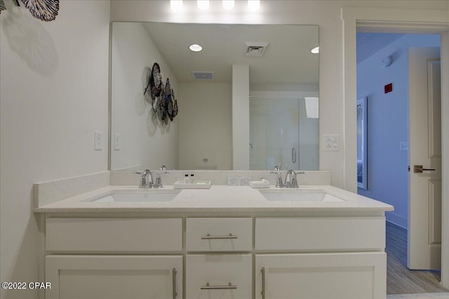 bathroom featuring double vanity and wood-type flooring