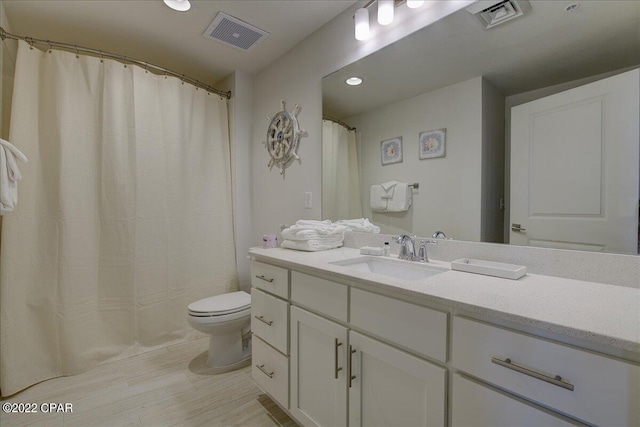 bathroom with toilet, tile floors, and vanity