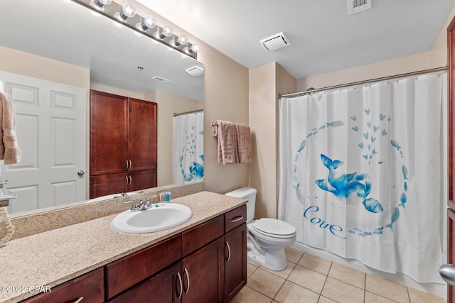 bathroom featuring toilet, vanity, and tile flooring