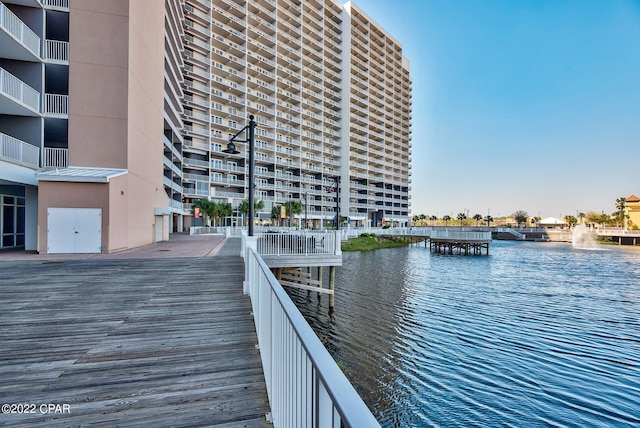 view of dock with a balcony and a water view