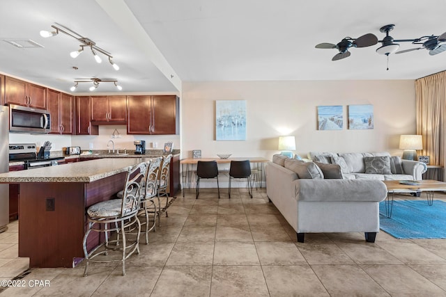 living room with rail lighting, light tile flooring, ceiling fan, and sink