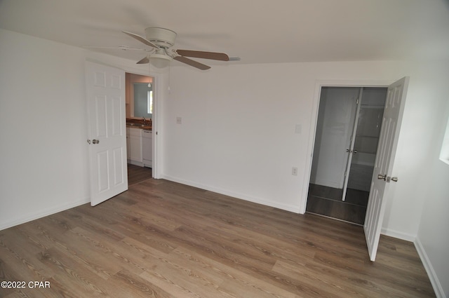 unfurnished bedroom with a closet, wood-type flooring, and ceiling fan