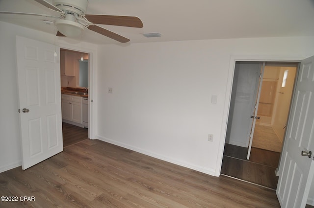 empty room with ceiling fan, dark wood-type flooring, and sink