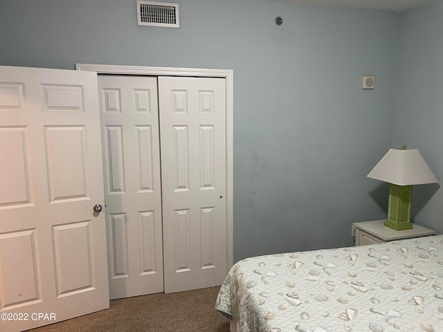 bedroom featuring a closet and dark colored carpet