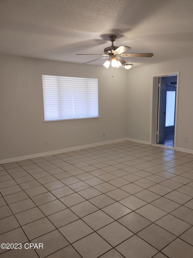 tiled empty room with a textured ceiling and ceiling fan