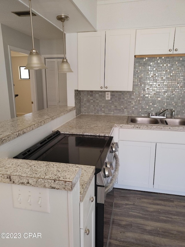 kitchen with dark hardwood / wood-style floors, hanging light fixtures, backsplash, stainless steel electric stove, and white cabinetry