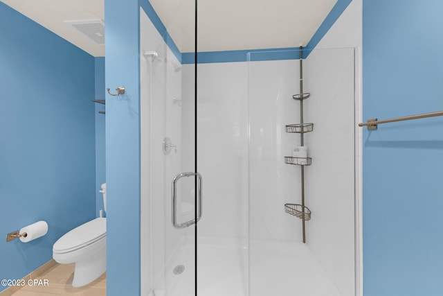 bathroom with toilet and a shower with shower door