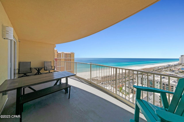 balcony with a water view and a view of the beach