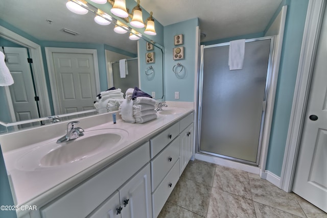 bathroom featuring dual sinks, a textured ceiling, tile flooring, a shower with shower door, and large vanity