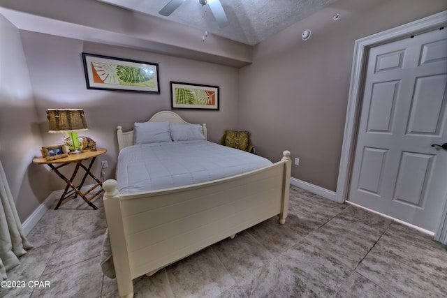 tiled bedroom with a textured ceiling and ceiling fan