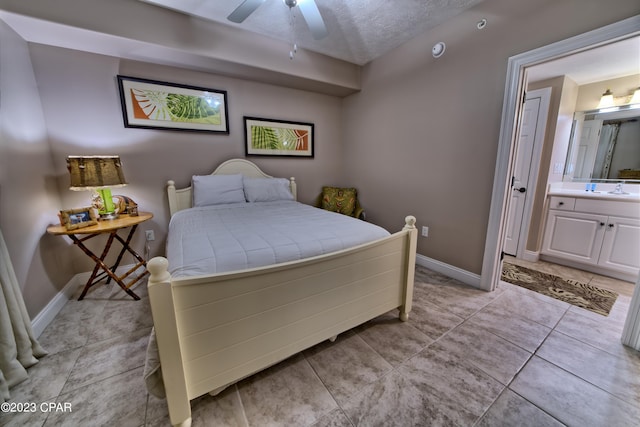 bedroom with ensuite bath, a textured ceiling, ceiling fan, and light tile floors