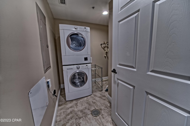 washroom featuring light tile floors and stacked washer / drying machine