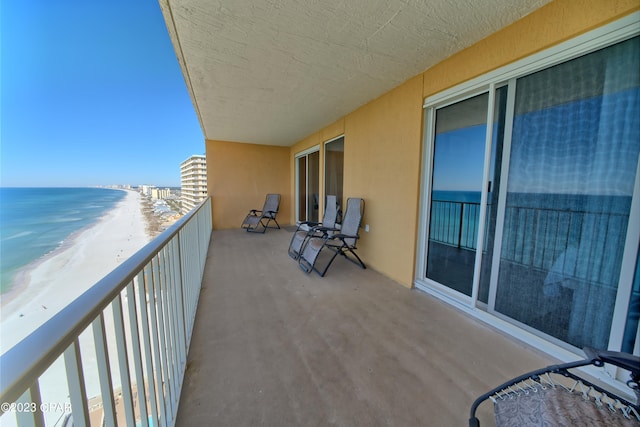 balcony featuring a beach view and a water view