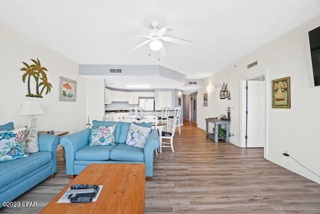 living room featuring ceiling fan and light hardwood / wood-style flooring