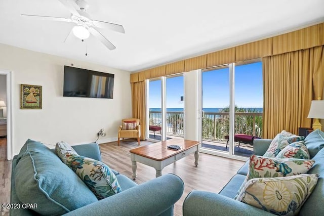 living room with a water view, ceiling fan, and light hardwood / wood-style flooring