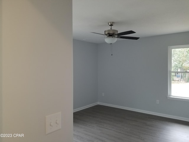 unfurnished room with plenty of natural light, dark hardwood / wood-style flooring, and ceiling fan