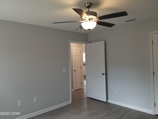 empty room with dark wood-type flooring and ceiling fan