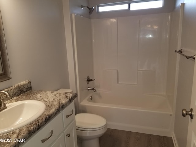 full bathroom with toilet, washtub / shower combination, large vanity, and hardwood / wood-style flooring