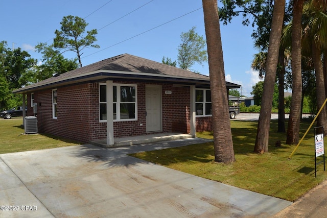 view of front of property with central AC unit and a front lawn