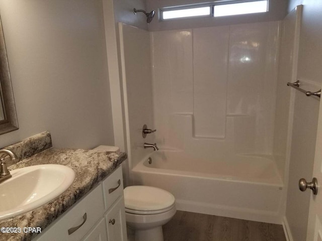 full bathroom featuring wood-type flooring, vanity with extensive cabinet space, toilet, and bathing tub / shower combination