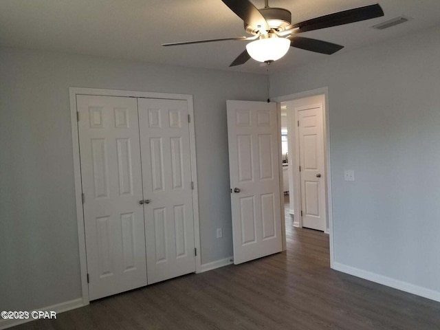 unfurnished bedroom with a closet, ceiling fan, and dark hardwood / wood-style flooring