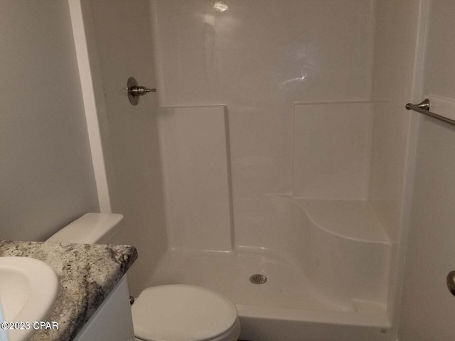 bathroom with toilet, walk in shower, and vanity