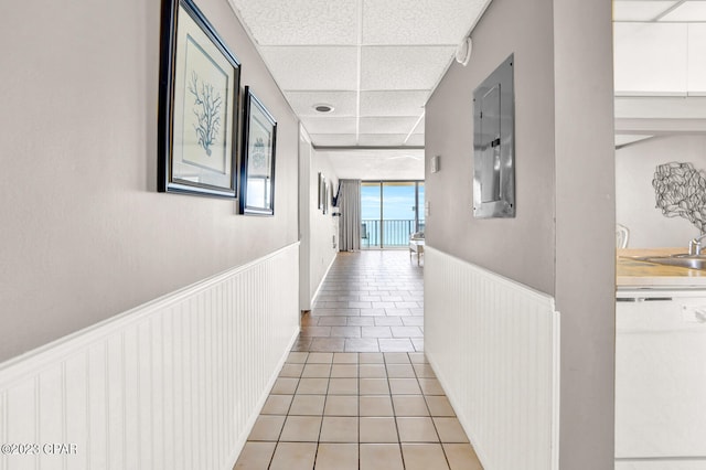 corridor featuring a drop ceiling and light tile floors