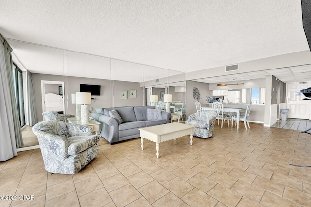 living room with light tile floors and a textured ceiling