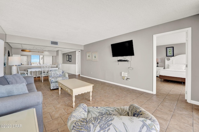 tiled living room featuring a textured ceiling