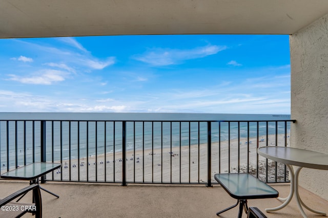 balcony featuring a beach view and a water view