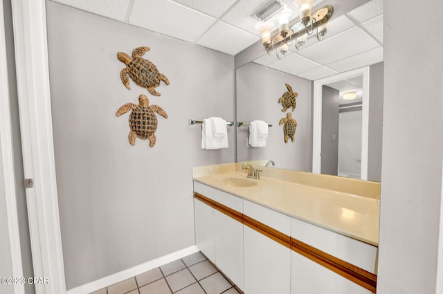 bathroom featuring a paneled ceiling, tile floors, and large vanity