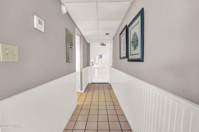 hallway featuring light tile flooring and a drop ceiling