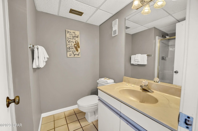 bathroom featuring toilet, large vanity, tile floors, and a drop ceiling