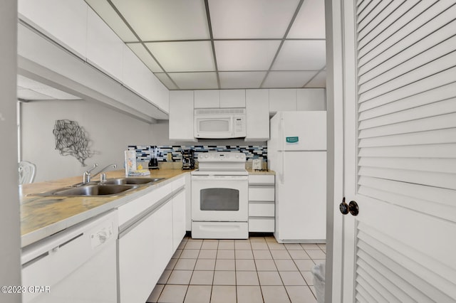 kitchen featuring backsplash, white appliances, sink, a paneled ceiling, and white cabinets